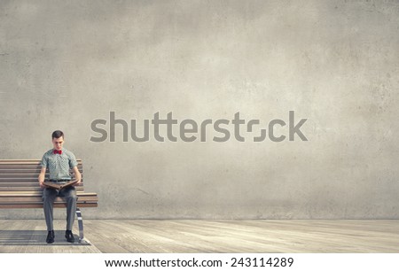 Young man student sitting with book in hands