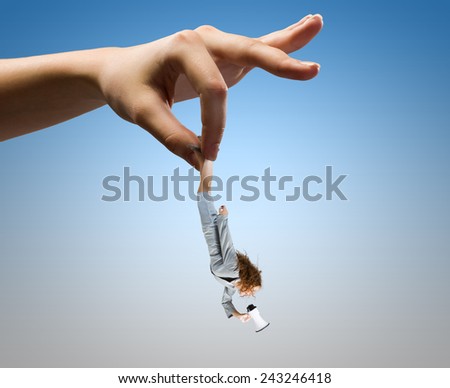 Giant human hand holding miniature of businesswoman