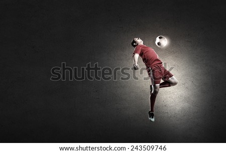 Football player in red shirt jump taking ball