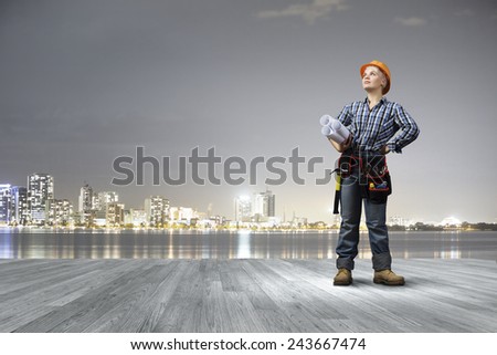 Young woman in hardhat with construction project in hands