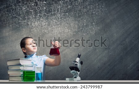Cute school girl at chemistry lesson with test tube