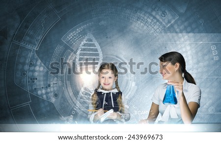 Young teacher and her pupil doing tests at chemistry lesson