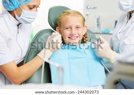 Cute smiling girl in at dentist sitting in armchair