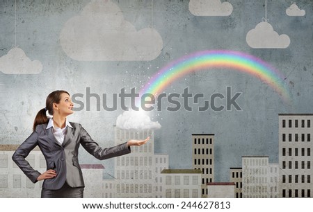Young businesswoman and colorful rainbow in hand