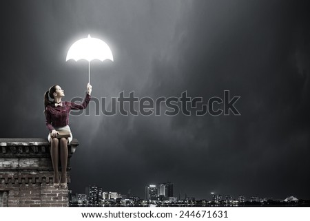 Young beautiful lady sitting on building roof and reading book