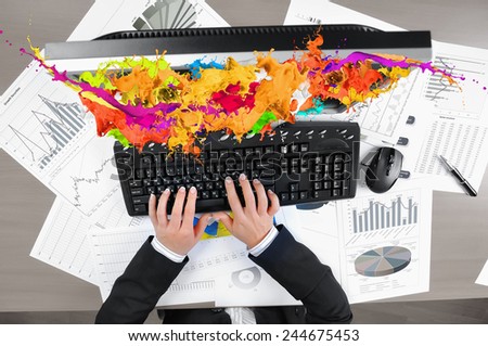 Hands of woman using computer keyboard and colorful splashes on screen