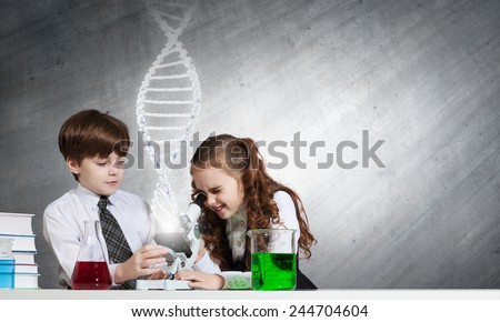 Two cute children at chemistry lesson making experiments