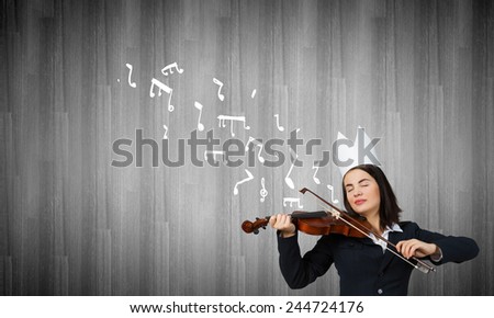 Young pretty businesswoman in paper crown playing violin