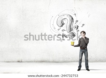 Young man in casual and question marks from bucket