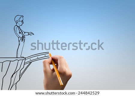 Human hand drawing caricature of man and bridge above gap