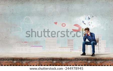 Troubled young man sitting in chair outdoors