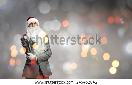 Thoughtful businessman in Santa hat with hand on chin