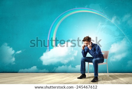 Troubled young man sitting in chair outdoors