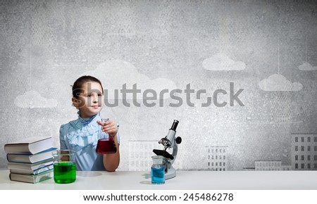 Cute school girl at chemistry lesson with test tube
