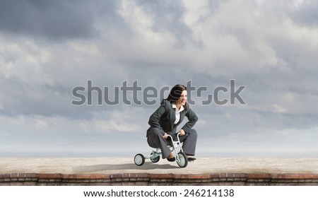 Young pretty businesswoman riding three wheeled bike