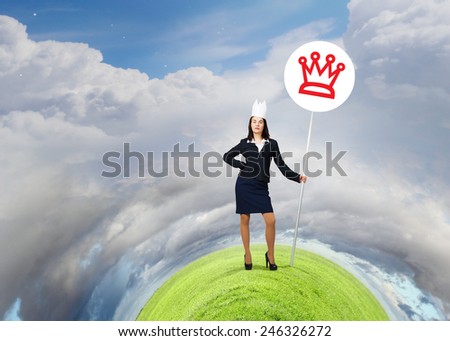 Young businesswoman in paper crown and sign in hands
