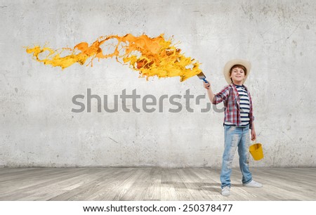 Boy of school age with yellow bucket and paint brush