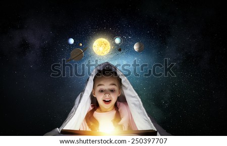 Cute girl of school age with book exploring space system