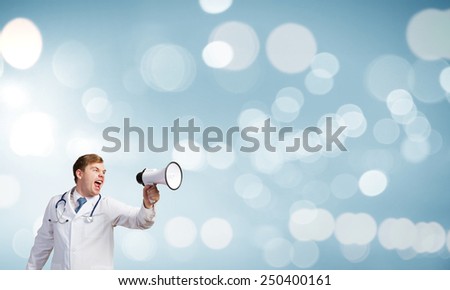 Young male doctor screaming in megaphone emotionally