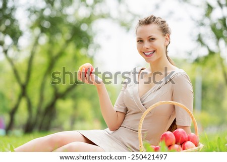 Young pretty woman in summer park with apple