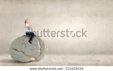 Young girl sitting on big human brain