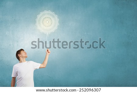 Young handsome smiling guy with balloon in hand against sky background