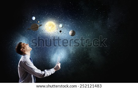 Young businessman using smart phone and planets of space spinning around