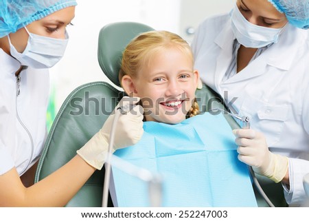 Cute smiling girl in at dentist sitting in armchair