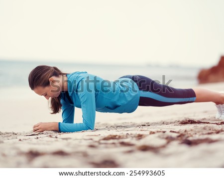 Sporty young woman exercising  on the sea coast