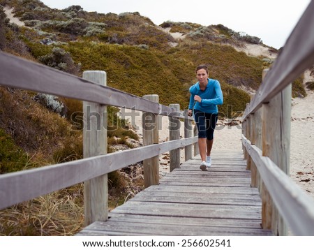 Sporty young woman running up the stairs