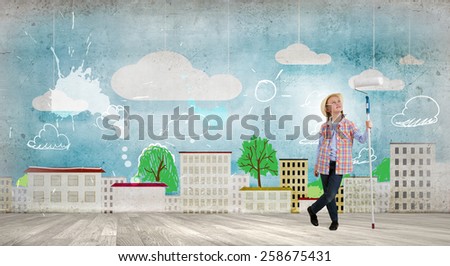 Cute girl of school age painting wall with roller