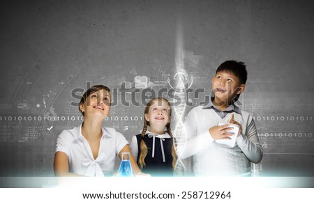 Young teacher and her pupils doing tests at chemistry lesson