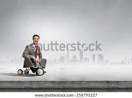 Young handsome businessman riding three wheeled bicycle