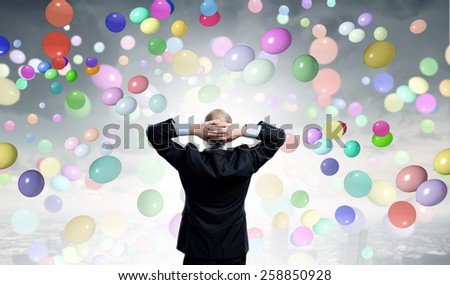 Rear view of businessman with arms on head thinking something over
