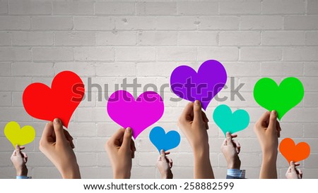 Close of many human hands with colorful cards