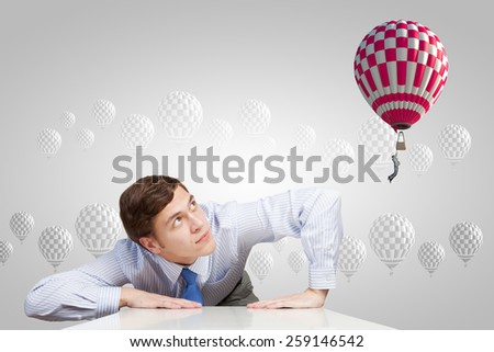 Young businessman leaning on table and looking at man in sky