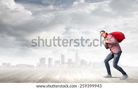 Young girl carrying red santa bag on back
