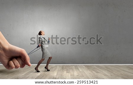 Young businesswoman with ropes on hands trying to escape