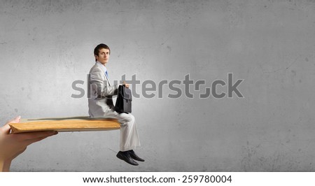 Young man sitting on old opened book