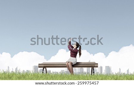 Young woman sitting on bench afraid of something
