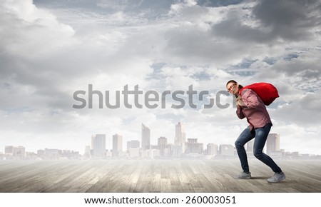 Young girl carrying red santa bag on back