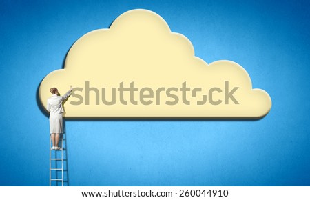 Rear view of businesswoman standing on ladder and reaching cloud