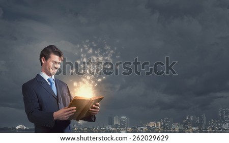 Handsome young man in suit with book in hands