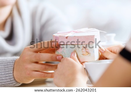 Close up image of hands presenting a box with surprise