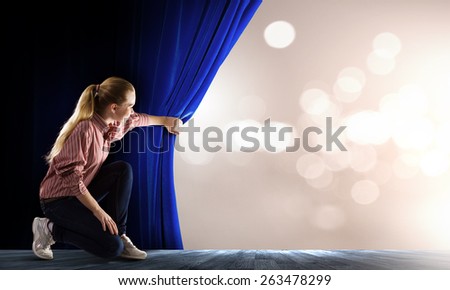 Young woman in casual with megaphone opening curtain