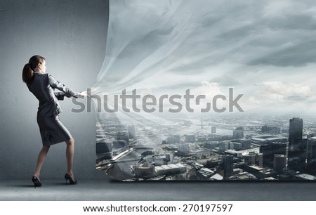 Young pretty businesswoman pulling clothing banner with illustration