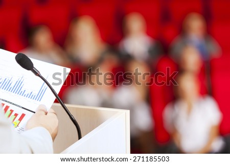 Businessman standing on stage and reporting for audience
