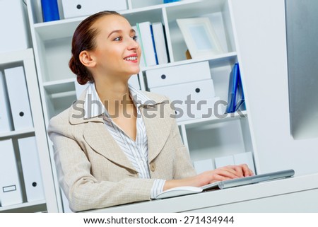 Attractive woman working in office on computer