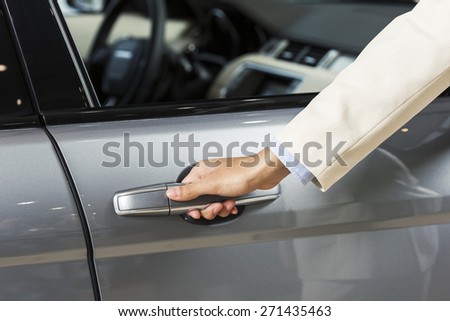 Close up of human hand opening door of car