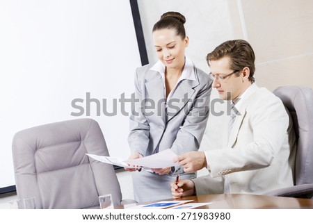 Young attractive secretary showing boss business documents